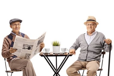 Son sınıflar kahve masasında oturup kameraya bakıyorlar. 