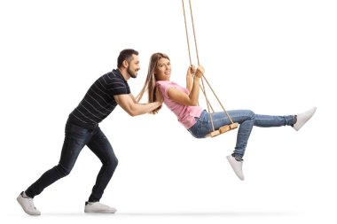 Genç bir kadını salıncakta sallayan adam.