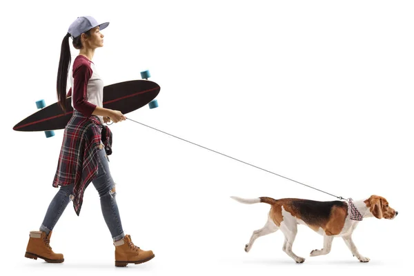 Female teenager with a skateboard walking a dog — Stock Photo, Image