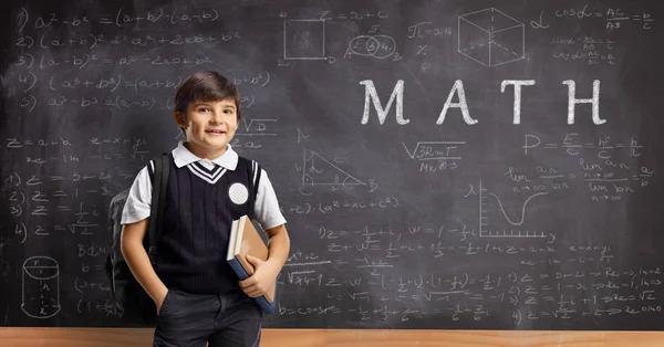 Écolier devant un tableau noir avec des formules mathématiques — Photo