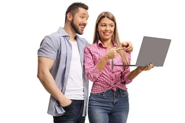 Young female pointing to a laptop screen with a young man — Stock Photo, Image