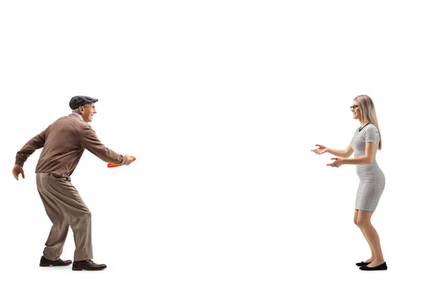 Senior man and a young woman playing with a plastic disk — Stock Photo, Image