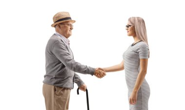 Yaşlı bir adam genç bir kadınla el sıkışıyor.