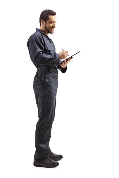 Trabajador en uniforme escribiendo un documento con un portapapeles — Foto de Stock