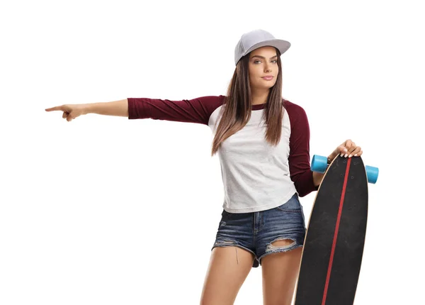 Attraktives Mädchen mit Skateboard, das in eine Richtung zeigt — Stockfoto