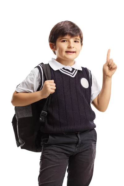 Симпатичный молодой школьник с книгами и рюкзаком, указывающим вверх — стоковое фото