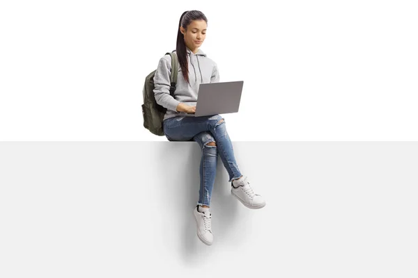 Vrouwelijke student zit op een leeg bord en met behulp van een laptop compu — Stockfoto