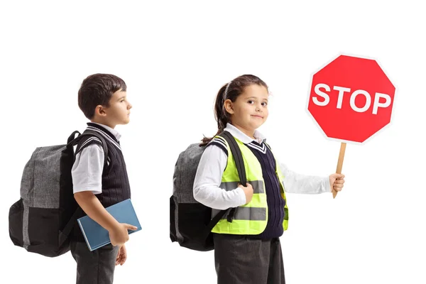 Schoolgirl and schoolboy wearing safety vests and holding a stop — Stock Photo, Image