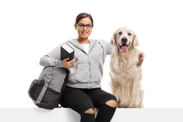 Jonge vrouw met boek zitten op een paneel met een labrador retriev — Stockfoto