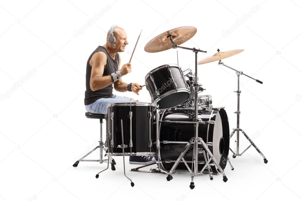 Male bald drummer with headphones playing drums 