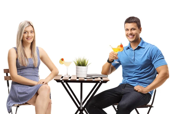 Couple sitting at a table with cocktails — Stock Photo, Image