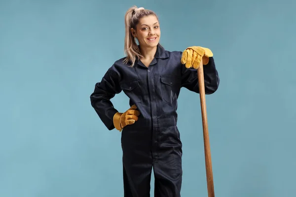 Bäuerin in Uniform stützt sich auf ein Arbeitsgerät — Stockfoto