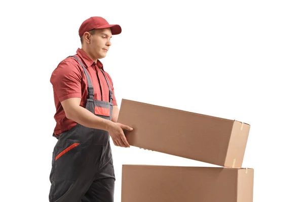 Mannelijke werknemer die een doos bovenop een stapel plaatst — Stockfoto