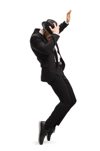 Young man in a suit dancing and holding his hat — Stock Photo, Image