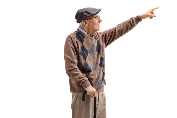 Senior man standing with a cane and pointing up in the distance — Stock Photo, Image