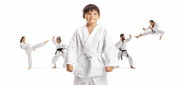 Boy in karate kimono standing in front and men and women exercis — 스톡 사진