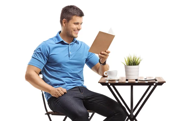 Man zit aan een salontafel en leest een boek. — Stockfoto