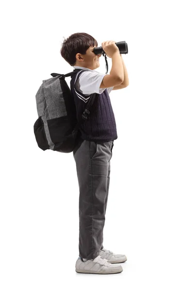 Colegial con una mochila mirando a través de binoculares — Foto de Stock