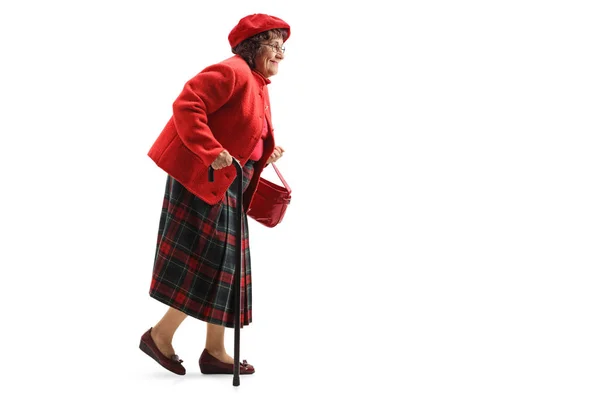 Leende äldre kvinna som går med käpp — Stockfoto