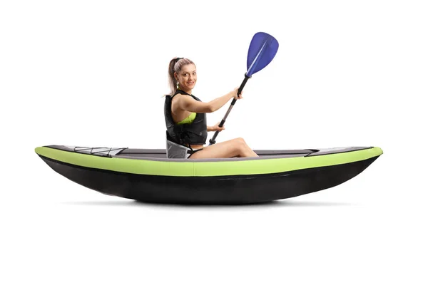 Ung kvinna med säkerhetsväst paddlar kanot — Stockfoto