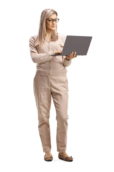 Junge Frau steht und arbeitet an einem Laptop — Stockfoto