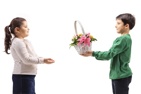 Niño dando una cesta con flores a una chica — Foto de Stock