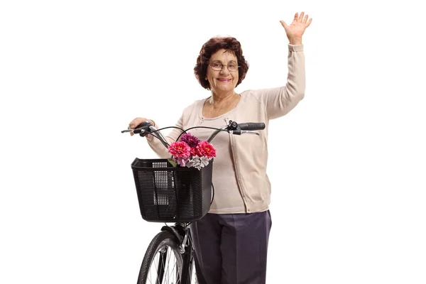 Μια ηλικιωμένη γυναίκα με ποδήλατο να χαιρετάει την κάμερα. — Φωτογραφία Αρχείου