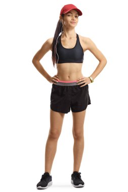 Spor giyimli, şapkalı ve kulaklıklı genç bir kadın.