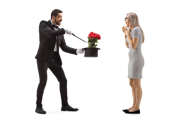 Magician making a magic trick with flowers and a hat in front of — Stockfoto