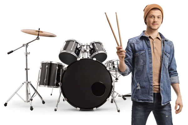 Young guy holding drumsticks and posing with a set of drums — Stock Photo, Image