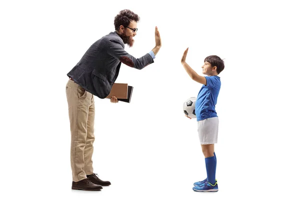 Boy in a jersey with a soccer ball gesturing high five with a ma — Stok fotoğraf