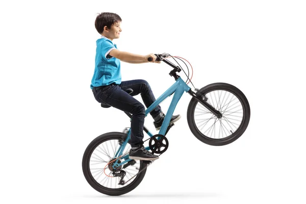 Мальчик выполняет велосипедную акробатику и едет с одним колесом вверх — стоковое фото