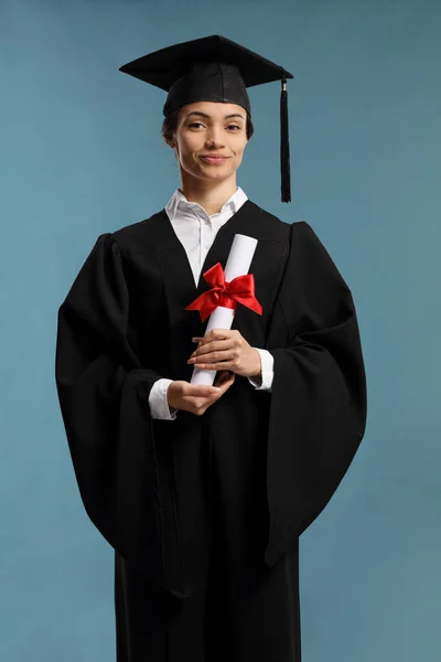 Estudiante con un vestido de graduación con un diploma — Foto de Stock