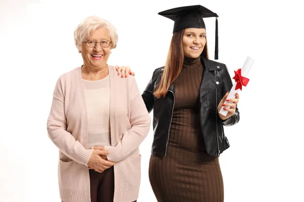 Giovane donna con un cappello di laurea e diploma in posa con un el — Foto Stock