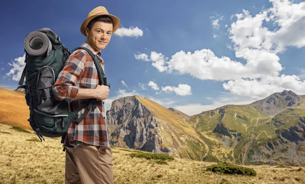 Ung manlig vandrare med ryggsäck på ett berg — Stockfoto