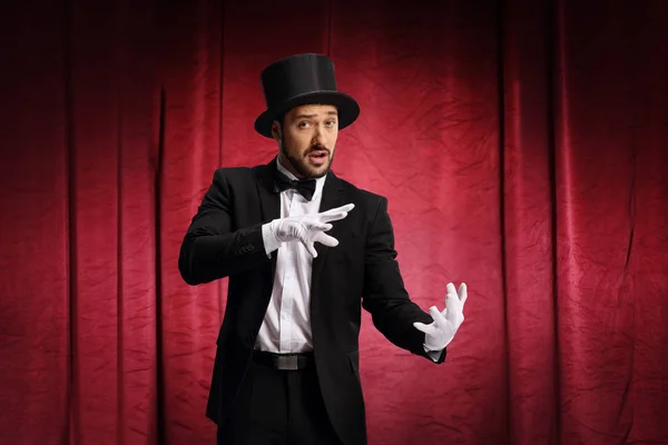 Male magician performing a trick with haon a stage — 스톡 사진