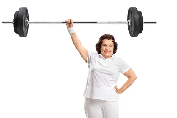 Oudere sterke vrouw tilt een lange halter met een hand — Stockfoto