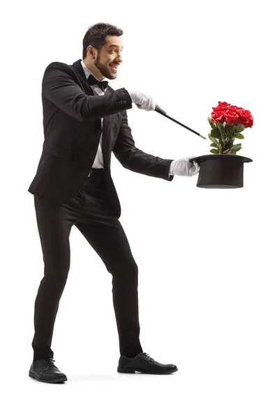 Mágico realizando um truque com chapéu e rosas vermelhas — Fotografia de Stock