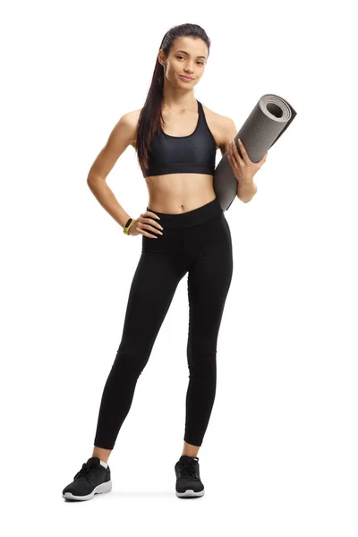 Retrato de comprimento total de uma jovem mulher segurando um tapete de exercício — Fotografia de Stock