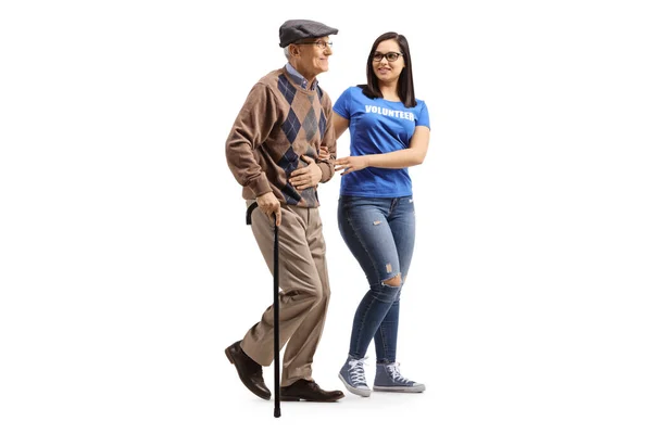 Молодая женщина-волонтер помогает пожилому мужчине с банкой для прогулок — стоковое фото