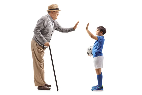 Grandson with a soccer ball gesturing high five with grandfather — Stok fotoğraf