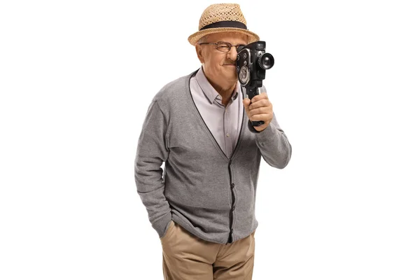 Elderly man recording with a vintage 8 mm camera — Stock Photo, Image