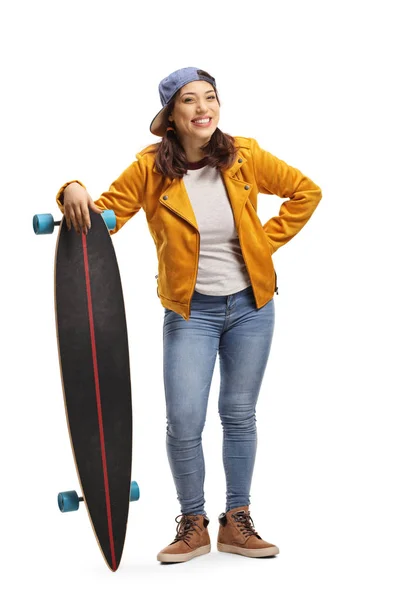Modna młoda kobieta z longboardem uśmiechnięta do kamery — Zdjęcie stockowe