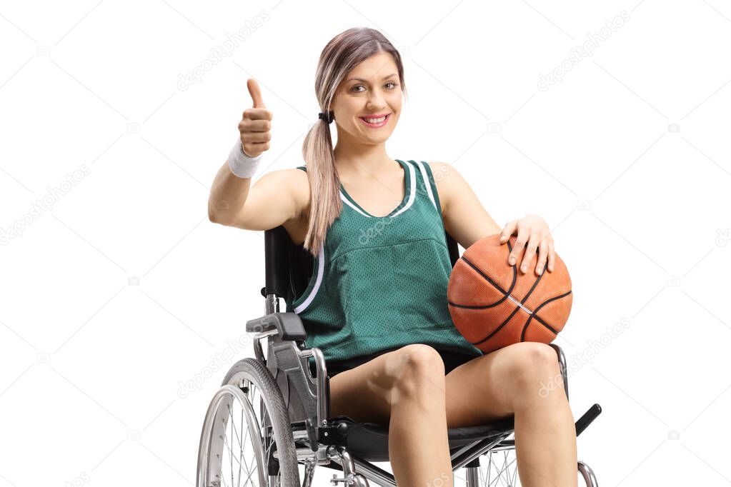 Young woman in a wheelchair holding basketball and showing thumb
