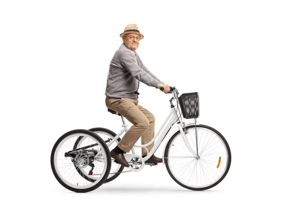 Пожилой человек на белом трехколесном велосипеде и улыбается в камеру — стоковое фото
