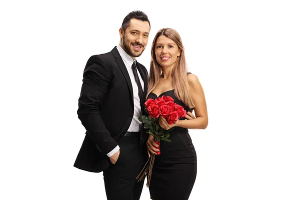 Young man and woman in elegant clothes with red roses — Stock Photo, Image