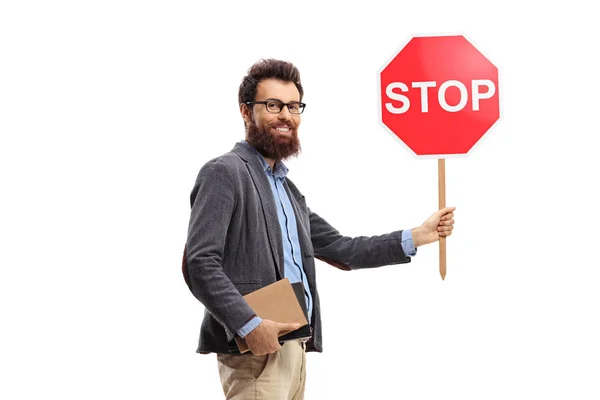 Bearded man holding books and a traffic stop sign — Stockfoto