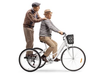 Elderly man riding a tricycle with another elderly man standing 