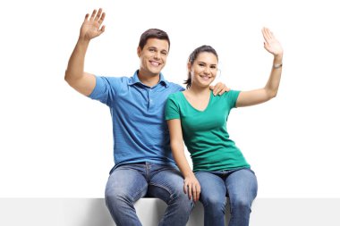 Couple sitting on a panel and waving at the camera