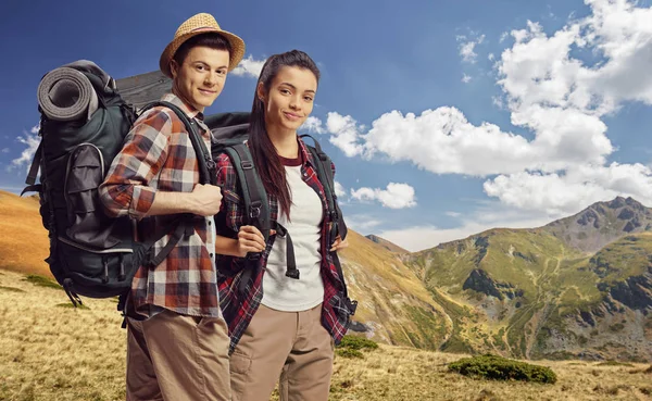 Young male and female hikers with backpacks posing — Stock Photo, Image